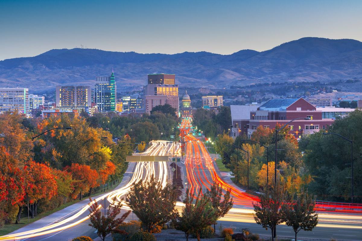Downtown Boise at dusk with the foothills rising behind the city.